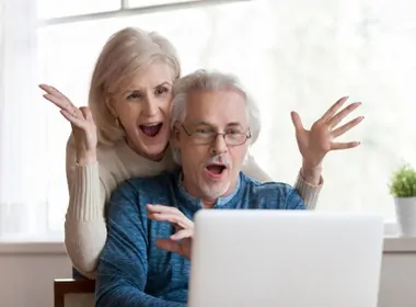 older couple winning online casino games on their laptop