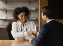 two young people, a man and a woman, shake hands as one has given the other some good advice