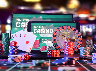 Three mobile devices of different sizes showing an online casino. The scene has chips, cards, a roulette wheel, and dice.